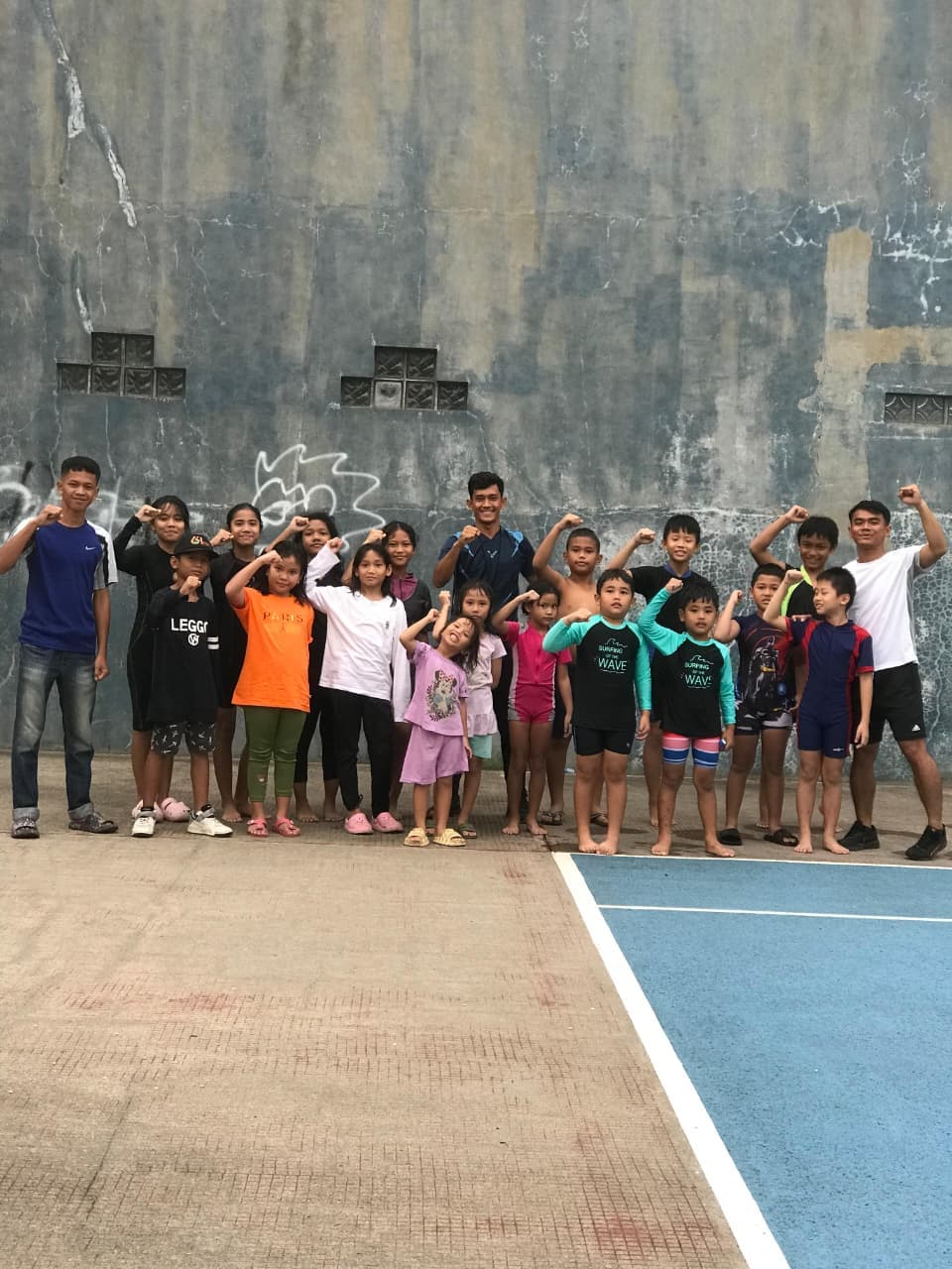 Seorang siswa berdiri percaya diri di pinggir kolam renang