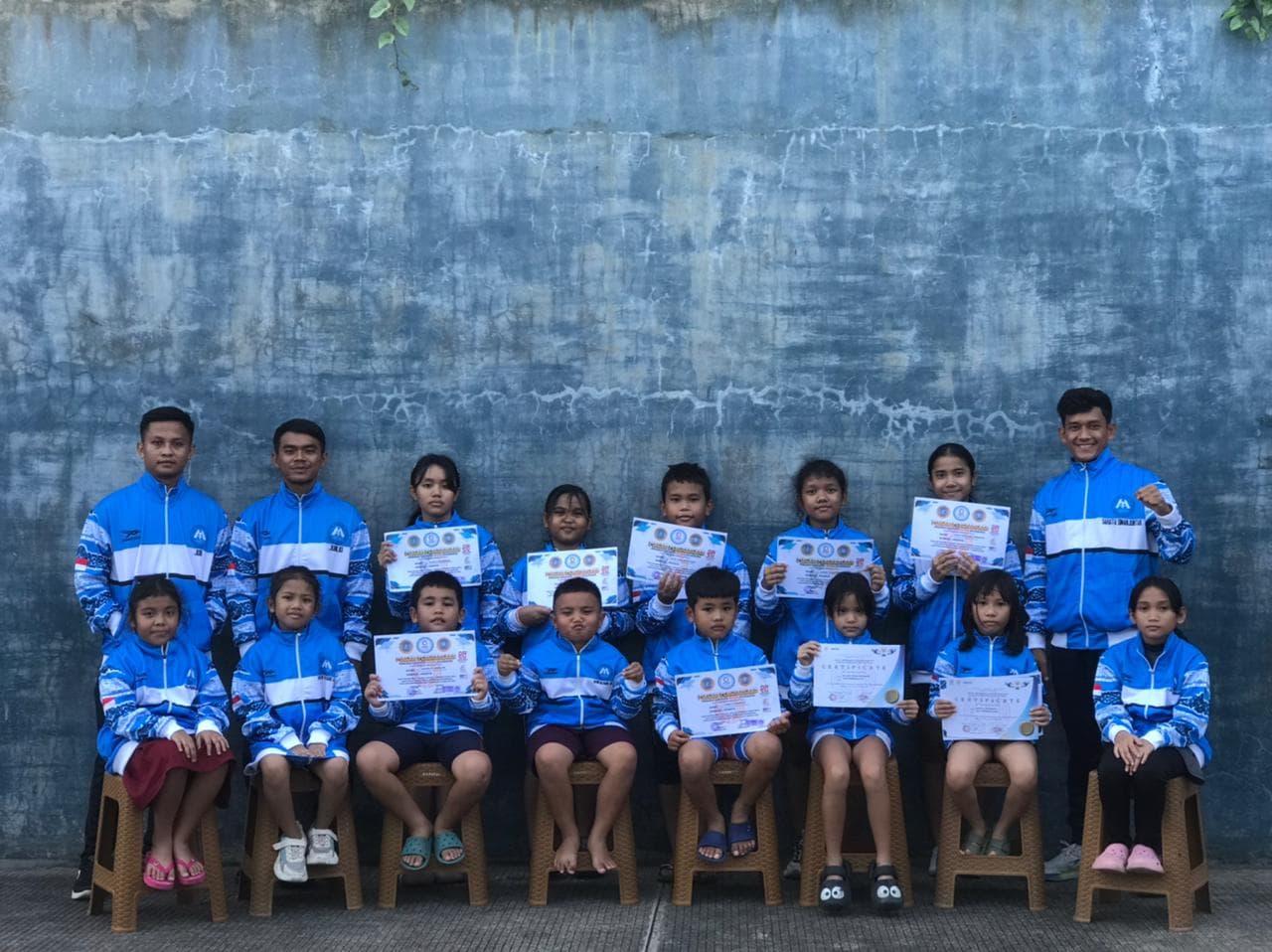 Pelatih mendampingi siswa selama latihan renang di kolam