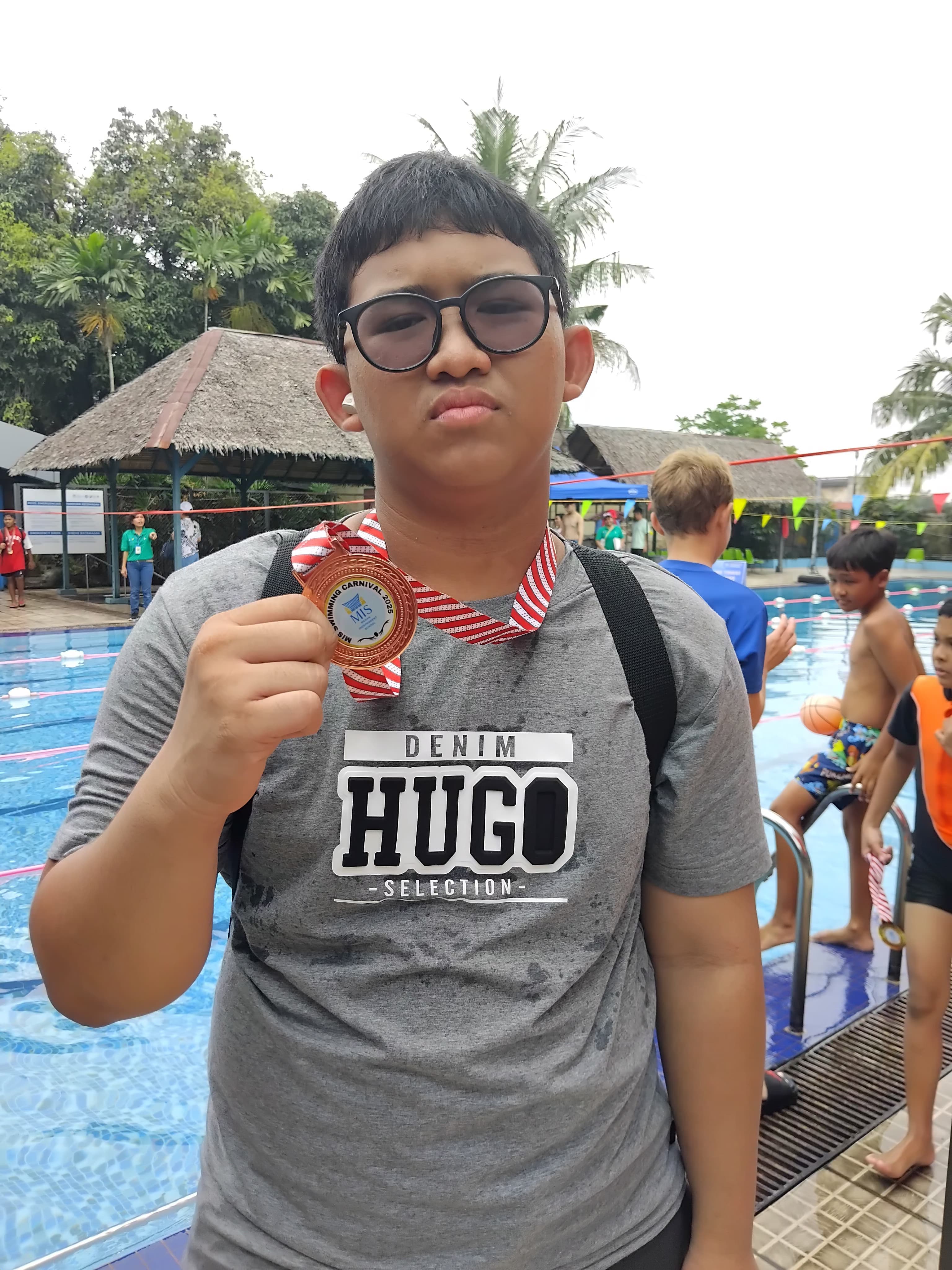 Atlet muda merayakan kemenangan dengan medali di arena